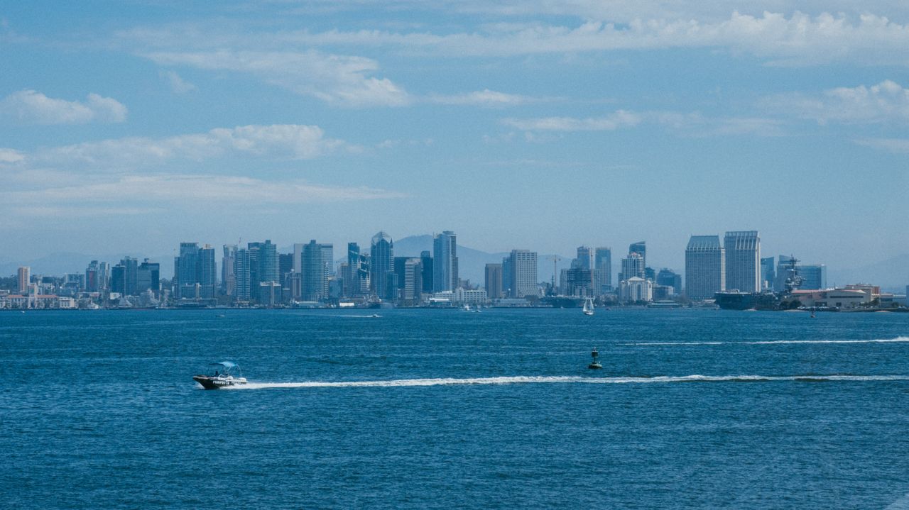 Stunning view of San Diego skyline and waterfront with boats under a clear blue sky.