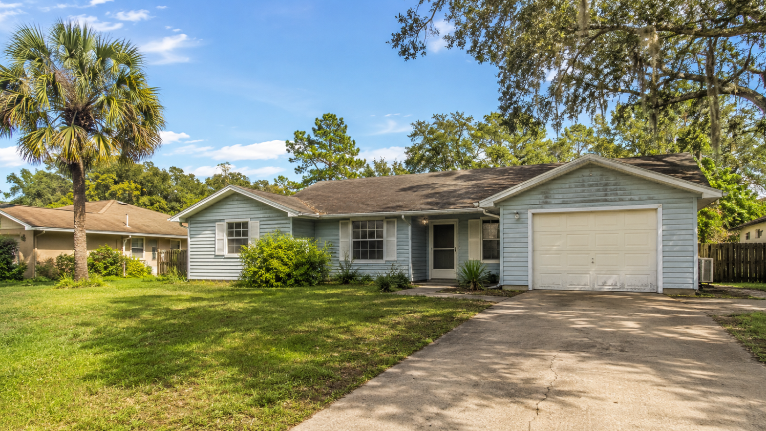 suburban home with greenery and driveway